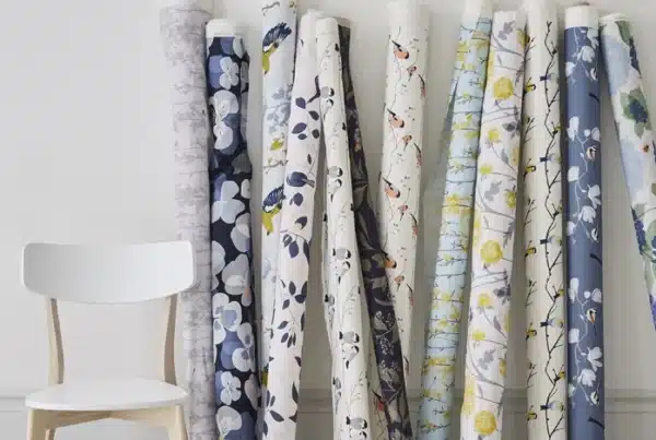 Designer's trade fabric swatches and fabric rolls against a wall