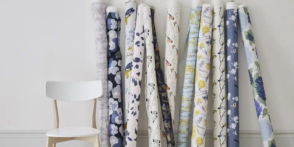 Designer's trade fabric swatches and fabric rolls against a wall